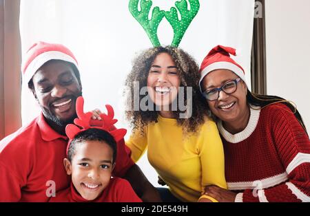 La famiglia multirazziale celebra il Natale insieme - gente felice che si diverte Durante le vacanze invernali - Focus principale sul volto della giovane donna Foto Stock