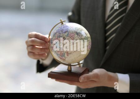 Primo piano di uomo d'affari che tiene il globo Foto Stock