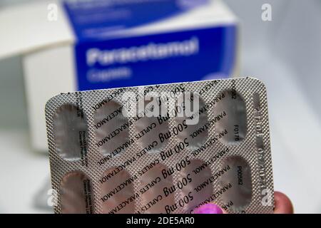 Durham, UK - 11 Aprile 2020: Le donne conservano Paracetamol in un pacchetto di fogli su sfondo bianco isolato con scatola su sfondo sfocato. Sollievo dal dolore, a casa m Foto Stock