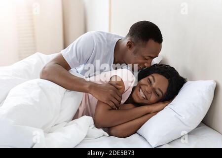 Nero amorevole giovane relax nel letto di casa Foto Stock