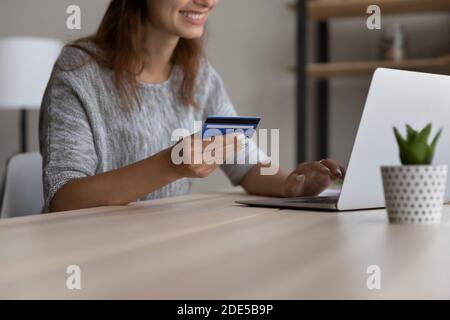 Felice giovane donna che inserisce informazioni di pagamento, shopping online. Foto Stock