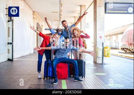 Gruppo multirazziale di amici alla stazione ferroviaria con bagaglio Maschera protettiva - nuovo concetto di stile di vita normale sul turismo e. giorni festivi durante Foto Stock