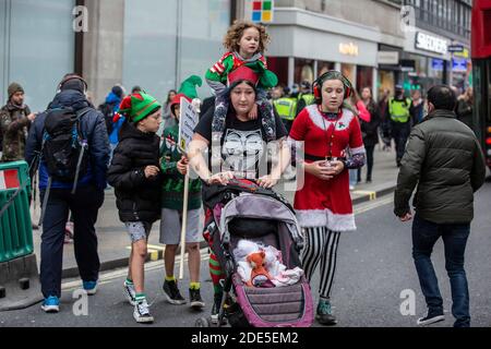 Una famiglia vestita di abiti natalizi che partecipa a manifestazioni anti-blocco su Oxford Street, nella capitale Londra, Inghilterra, Regno Unito Foto Stock