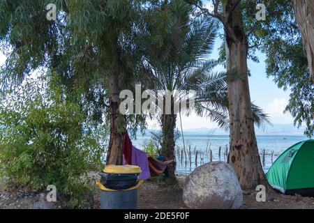 Vista del mare di Galilea sullo sfondo delle alture del Golan in Israele. Campeggio sulle rive del mare di Galilea. Tenda rossa. Cielo nuvoloso. Foto di alta qualità Foto Stock