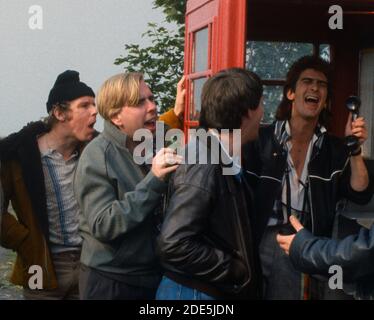 Azione da una scatola telefonica rossa - cast originale di La produzione ATV di Auf Wiedersehen PET fotografata a a. Nottinghamshire luogo luglio 1986 Foto Stock