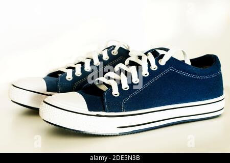 Un paio di scarpe in tessuto blu su sfondo bianco. Ciabatte estive Foto Stock