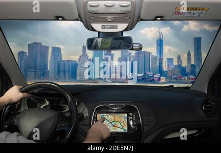 Guida di un'auto utilizzando il touch screen di un sistema di navigazione GPS il quartiere finanziario di Manhattan, New York City, USA Foto Stock