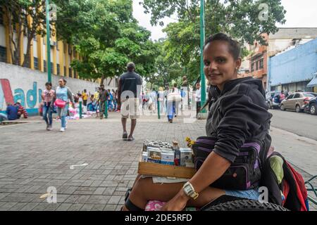 Caracas, Miranda, Venezuela. 27 Nov 2020. Eunice Valecillos (32) vende sigari dettagliati dalla sua sedia a rotelle, come supporto vitale. In passato era su un altro viale, Sabana Grande, ma a causa della pandemia, rimase su un altro più vicino alla sua casa. Questa è la seconda opportunità per includere l'intero paese nei giorni di flessibilità dall'inizio della pandemia nel marzo di quest'anno. Questo perché tutti gli stati venezuelani possono rilanciare la loro economia durante i sette giorni. Così, a partire da questo Lunedi, 21 settembre, e a causa della grande flessibilità, possono aprire centri commerciali, palestre, caffetteria Foto Stock