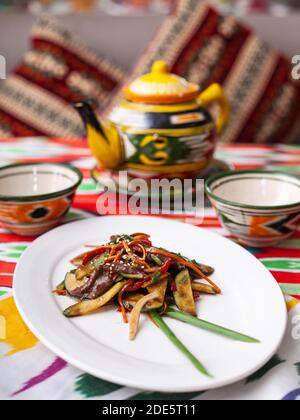 Insalata calda orientale. Pezzi di manzo, marcovi e cetrioli fritti in salsa e semi di sesamo. Stile Asiatico Foto Stock