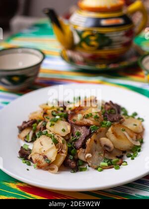 Patate fritte con pezzi di carne. Stile Asiatico Foto Stock