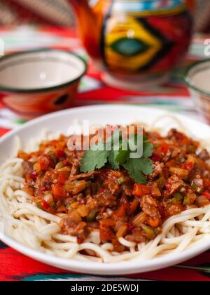 Il piatto orientale guiru lagman è noodle fatte in casa fritte con carne, verdure ed erbe. Cucina orientale Foto Stock