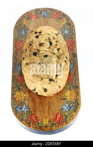 Stollen di Natale sassone tradizionale appena sfornato ancora senza zucchero in polvere termina su un tagliere in legno d'epoca isolato su bianco sfondo Foto Stock