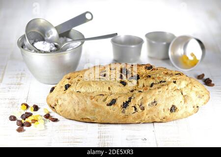 Stollen di Natale sassone tradizionale appena sfornato con alcuni ingredienti da forno da rifinire con zucchero in polvere Foto Stock