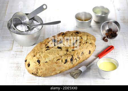 Stollen di Natale sassone tradizionale appena sfornato con alcuni ingredienti da forno da rifinire con zucchero in polvere Foto Stock
