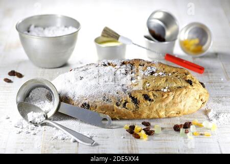 Stollen di Natale sassone tradizionale appena sfornato con alcuni ingredienti da forno da rifinire con zucchero in polvere Foto Stock