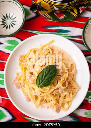 Pasta cremosa con pollo, basilico e funghi, secondo la ricetta italiana. Stile orientale Foto Stock