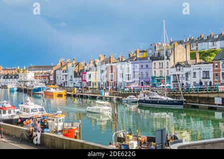 WEYMOUTH, Regno Unito - 28 AGOSTO 2020: L'esterno degli edifici lungo il porto di Weymouth a Dorset, Inghilterra. Edifici colorati possono essere visti, così come barche e Foto Stock