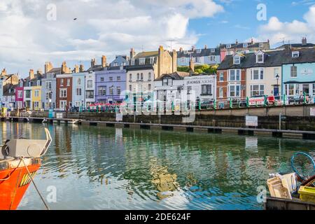 WEYMOUTH, Regno Unito - 28 AGOSTO 2020: L'esterno degli edifici lungo il porto di Weymouth a Dorset, Inghilterra. Edifici colorati possono essere visti, così come barche e Foto Stock