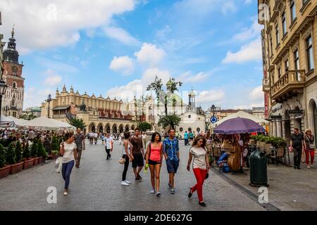 Cracovia, Polonia - 29 luglio 2018: Turisti in via Grodzka nella piazza principale del mercato, con la Sala dei tessuti sullo sfondo e caffè in primo piano, Foto Stock