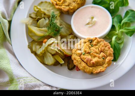 Colazione salutare - muffin vegetali vegani con salsa chili-mayo leggera e insalata di sottaceti di cetrioli, primo piano nella splendida luce naturale del mattino Foto Stock
