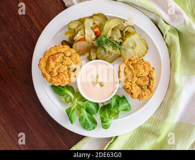 Antipasto a base di piante - muffin vegetali vegani con salsa leggera di peperoncino-mayo e insalata di sottaceti di cetrioli, primo piano, lattuga di agnello Foto Stock