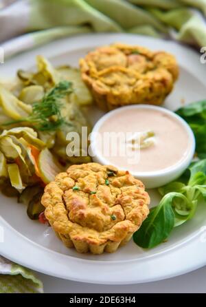 Colazione salutare - muffin alle verdure con salsa chili-mayo leggera e insalata di sottaceti di cetrioli, primo piano, luce del mattino presto Foto Stock