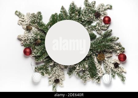 Spazio vuoto rotondo per il menu di natale e Capodanno o testo di invito con rami di abete e decorazione. Concetto di vacanza invernale a posa piatta. Vista dall'alto Foto Stock