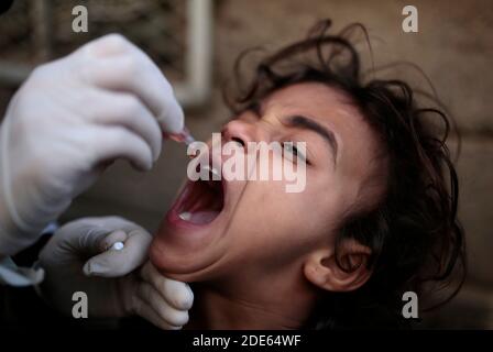 Sanaa, Yemen. 29 Nov 2020. Un operatore sanitario yemenita vaccina un bambino contro la polio nell’ambito di una campagna nazionale di vaccinazione di tre giorni casa a casa per vaccinare più di 5 milioni di bambini in tutto lo Yemen. Credit: Hani al-ANSI/dpa/Alamy Live News Foto Stock