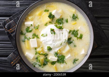 Colazione venezuelana tradizionale di brodo di pollo, con patate, uova, formaggio e coriandolo primo piano in una ciotola sul tavolo. Vista dall'alto orizzontale Foto Stock