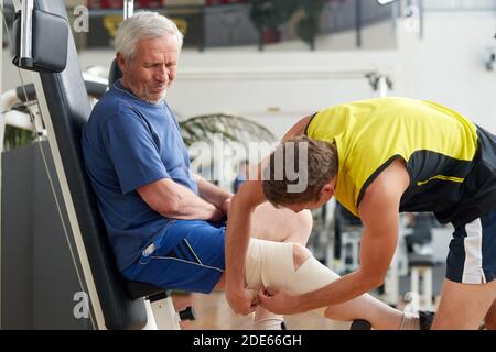 Uomo anziano che soffre di dolore al ginocchio. Foto Stock