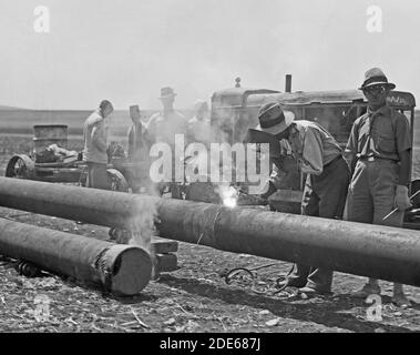 Storia del Medio Oriente - posa della linea di condotta della Compagnia petrolifera irachena attraverso la pianura di Esdraelon Luglio 1933. Saldatura della tubazione. Mediante il metodo di saldatura della flotta elettrica Foto Stock