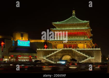 Vista notturna del Campanile illuminato di Xi'an con traffico offuscato che passa di fronte ad esso, Xi'an, Cina Foto Stock