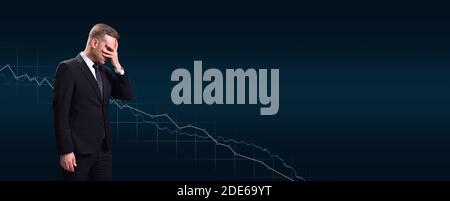 Uomo d'affari che copre il suo volto in shock a calo profitto su sfondo del grafico Foto Stock