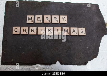 Belfast UK, 29 novembre. Le parole buon Natale, scritto in piastrelle di legno su una base ardesia credito Bonzo/Alamay Live News Foto Stock