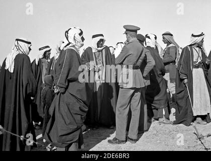 Didascalia originale: Un pranzo tribale al posto della cavalleria a Tel-el-Meleiha 20 miglia a nord di Beerseba Gennaio 18 1940. Ospiti in piedi circa in conversazione dopo il pasto vicino - posizione: Israele ca. 1940 Foto Stock