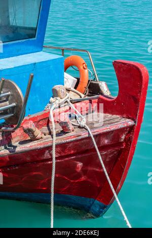 I colorati archi dipinti di una tradizionale barca da pesca greca o mediterranea in una giornata di sole con corde e reti. Foto Stock