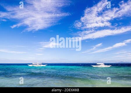 Barche Outrigger localmente chiamate banca al largo della costa di Bohol, Filippine Foto Stock