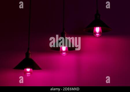 Tre lampade con lampadine a incandescenza vintage in luce rosa Foto Stock