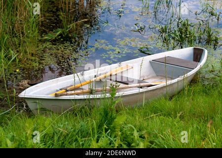 Solitaria piccola barca di legno sul lago. Foto Stock