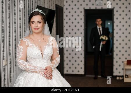 lo sposo incontra la sposa e dà un bouquet di fiori in camera Foto Stock