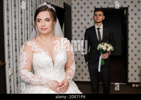 lo sposo incontra la sposa e dà un bouquet di fiori in camera Foto Stock