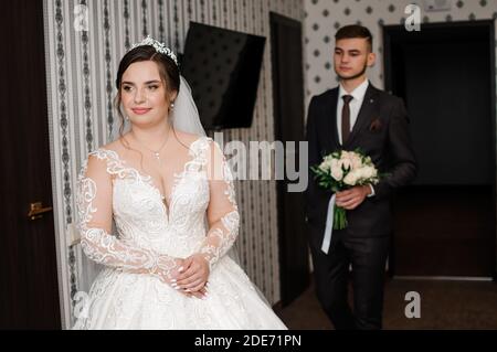 lo sposo incontra la sposa e dà un bouquet di fiori in camera Foto Stock