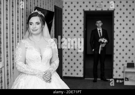 lo sposo incontra la sposa e dà un bouquet di fiori in camera Foto Stock