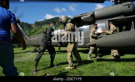 San Pedro Sula, Honduras. 28 Nov 2020. Soldati hondurani aiutano a scaricare forniture umanitarie da un elicottero dell'esercito degli Stati Uniti UH-60 Black Hawk nel periodo successivo all'uragano Iota 28 novembre 2020 a San Pedro Sula, Honduras. Tornando indietro gli uragani ETA e Iota hanno attraversato l'America Centrale distruggendo grandi tratti della costa e le strade delle inondazioni. Credito: Tsgt. Christopher Drzazgows/US Air Force/Alamy Live News Foto Stock