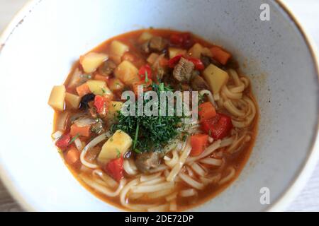 Laghman in ciotola bianca sul tavolo nel ristorante Foto Stock