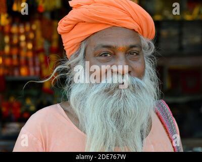 Vecchio indù uomo santo indiano (sadhu, baba, guru) con barba piena bianca spessa e occhi amichevoli pone per la macchina fotografica durante il festival Shivratri Mela. Foto Stock