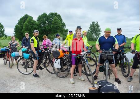 Gruppo di ciclisti felici, ciclisti viaggiatori onda le loro mani, Russia, regione di Kaliningrad, 13 giugno 2020 Foto Stock