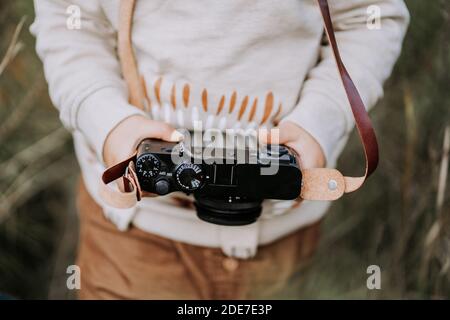 Primo piano delle mani dei bambini con la fotocamera retrò vintage. Ragazzo che studia per scattare foto. Foto Stock