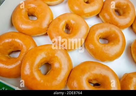 Una scatola aperta di una dozzina di ciambelle originali Krispy Kreme è raffigurata al Krispy Kreme Donuts, 28 novembre 2020, a Ocean Springs, Mississippi. Foto Stock