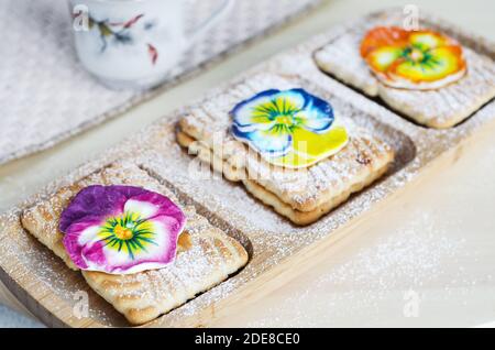 Biscotti decorati con fiori di zucchero e zucchero in polvere. Messa a fuoco selettiva Foto Stock